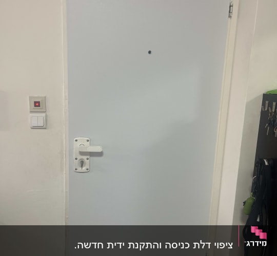 דלת לבנה עם ידית כסופה ומנעול